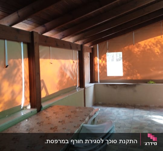 סוככים כתומים תלויים על קירות עץ עם חבלים לבנים